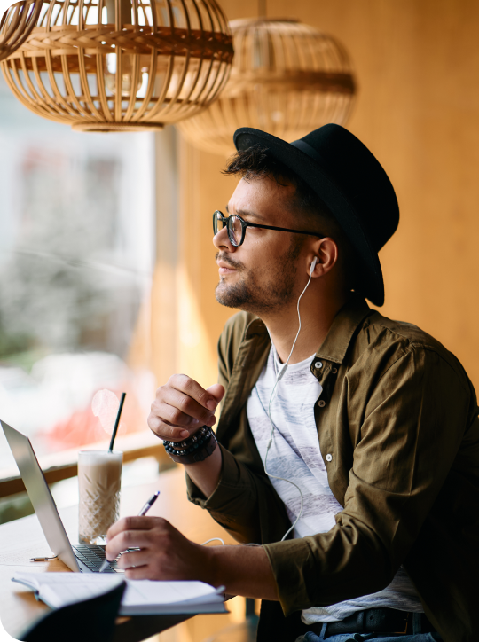 Young pensive student taking notes while e learning lg
